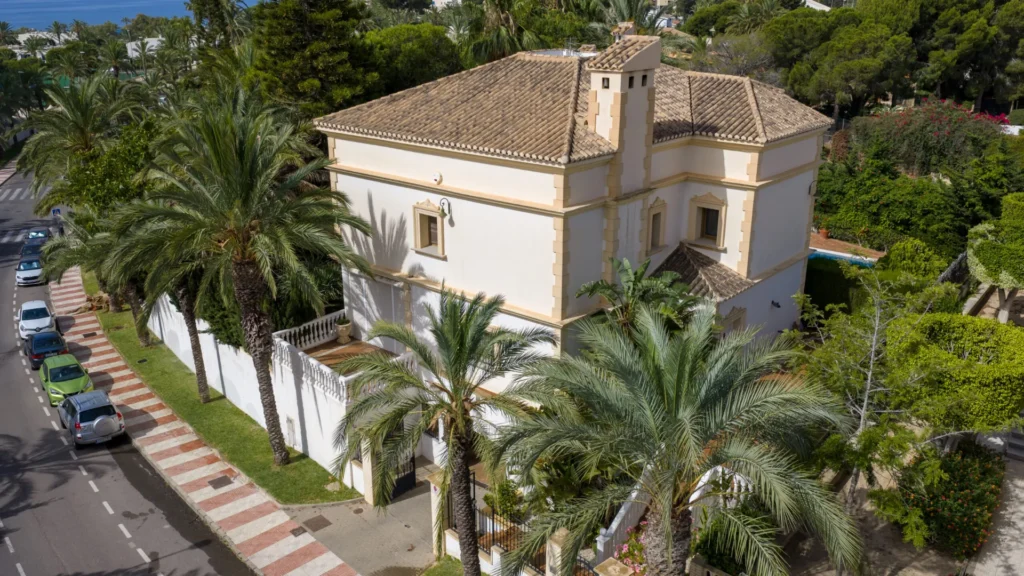 Fachada del chalet entre palmeras, vista desde dron